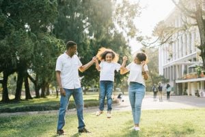 Joyful family enjoying a playful day at the park, embracing love and togetherness under the summer sun.
